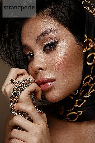 Schöne asiatische brünette Modell mit Volumen Locken  klassische Make-up und sexy Lippen. Die Schönheit des Gesichts. Porträtaufnahme im Studio