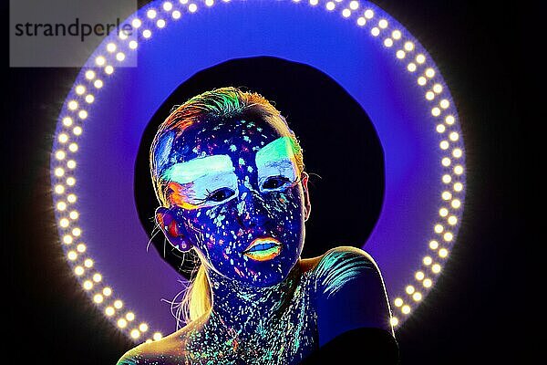 Porträt eines schönen Mädchens mit ultravioletter Farbe im Gesicht. Mädchen mit Neon-Make-up in Farbe Licht