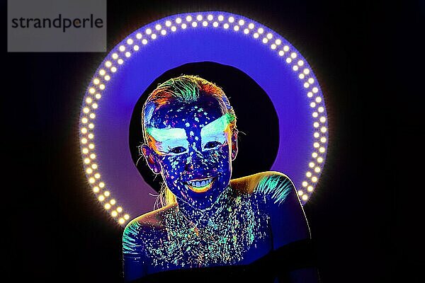 Porträt eines schönen Mädchens mit ultravioletter Farbe im Gesicht. Mädchen mit Neon-Make-up in Farbe Licht