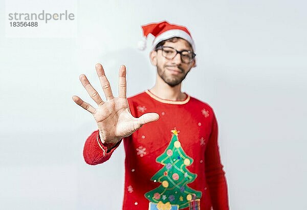 Mann in Weihnachtsmütze zählt mit den Fingern die Zahl fünf. Mann im Weihnachtskostüm zählt Nummer fünf mit den Fingern. Konzept der Mann im Weihnachtskostüm Zählen von Nummer fünf isoliert