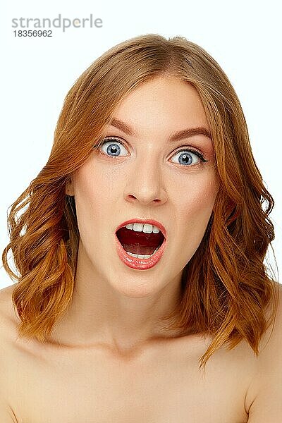 Porträt einer überraschten jungen Frau mit weit geöffnetem Mund. Blaue Augen und rote Lippen. Schönheit Porträt  frische Haut. Natürliches Make-up