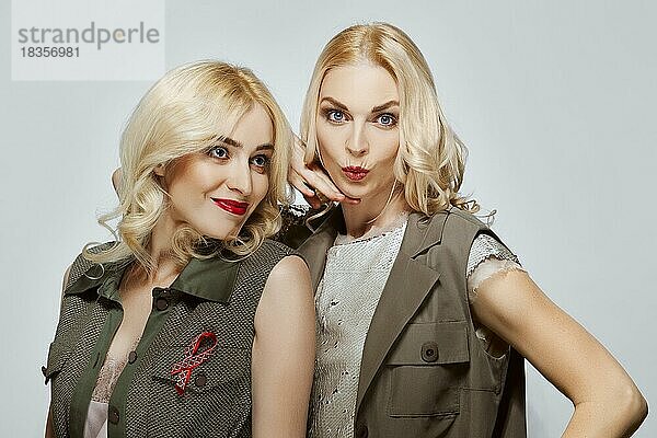 Zwei glückliche und fröhliche attraktive blonde Mädchen  natürliches Make-up  rote Lippen und blaue Augen
