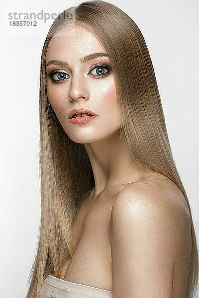 Schönes blondes Mädchen mit einem perfekt glatten Haar und klassischem Make-up. Schönes Gesicht. Bild im Studio aufgenommen