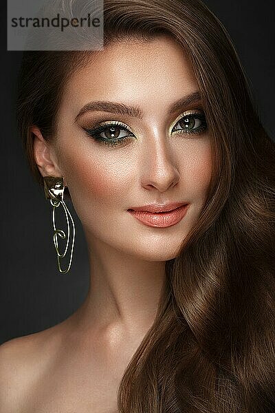Schönes Mädchen mit hellen modischen Make-up und ungewöhnliche Gold-Accessoires. Schönes Gesicht. Foto im Studio aufgenommen