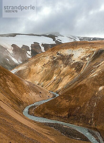 Dampfender Bach zwischen bunten Rhyolith Bergen und Schneefeldern  Geothermalgebiet Hveradalir  Kerlingarfjöll  isländisches Hochland  Island  Europa