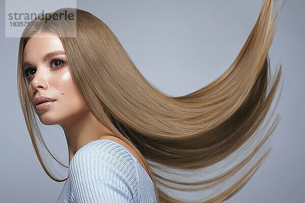 Schönes blondes Mädchen mit einem perfekt glatten Haar und klassischem Make-up. Schönheit Gesicht und Haar. Bild im Studio aufgenommen