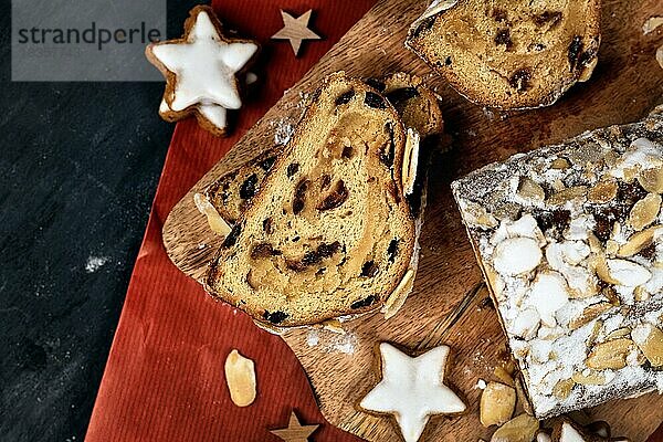 Draufsicht auf ein Stück deutschen Stollen  ein Früchtebrot mit Nüssen  Gewürzen und getrockneten Früchten mit Puderzucker  das traditionell zur Weihnachtszeit auf einem Holzbrett serviert wird