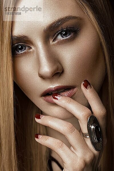 Schöne blonde Frau mit gesunder Haut und Haaren  rote Maniküre  posiert im Studio. Schönheit Gesicht