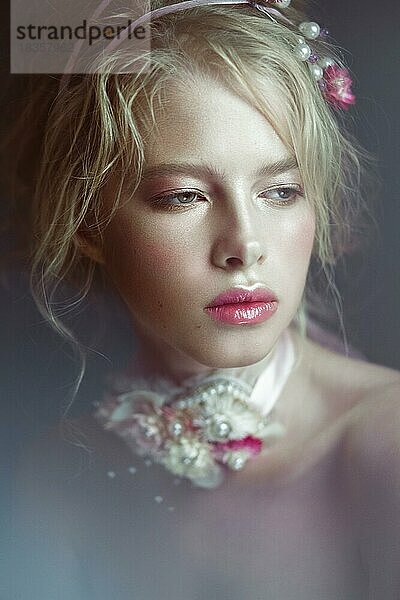 Schöne blonde Mode Mädchen mit Blumen auf den Hals und in den Haaren  nass Nude Make-up. Schönes Gesicht. Fotos im Studio geschossen