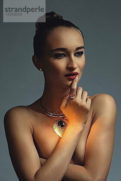Dunkles und stimmungsvolles Foto einer großen goldenen Halskette an einem Modell
