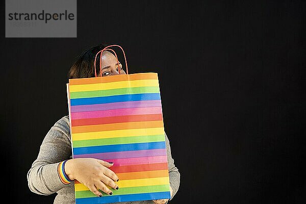 Frau hält Igbt-Tasche. Freude am Konsum. Käufe  schwarzer Freitag  Rabatte  Verkauf Konzept. Schwarzer Hintergrund