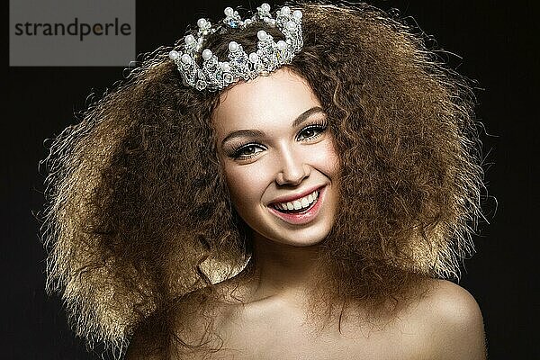 Schönes Mädchen mit einer Krone in Form einer Prinzessin. Bild im Studio auf einem schwarzen Hintergrund genommen