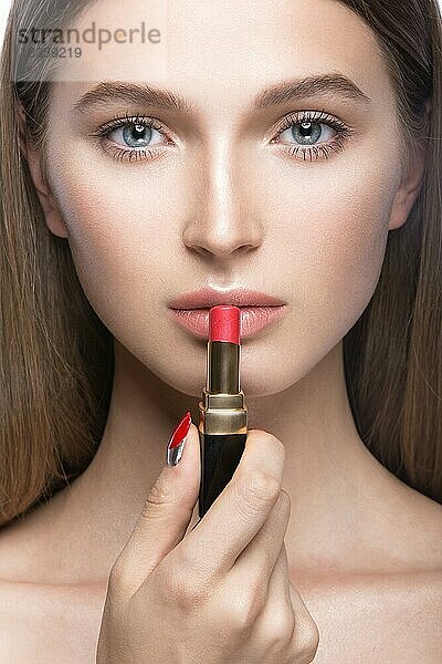Schönes junges Mädchen mit einem leichten natürlichen Make-up und Beauty-Tools in der Hand. Bild im Studio auf einem weißen Hintergrund aufgenommen