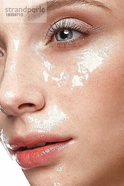 Schönes junges Mädchen mit leichtem Natur-Make-up und perfekter feuchter Haut. Schönes Gesicht. Bild im Studio auf einem weißen Hintergrund aufgenommen