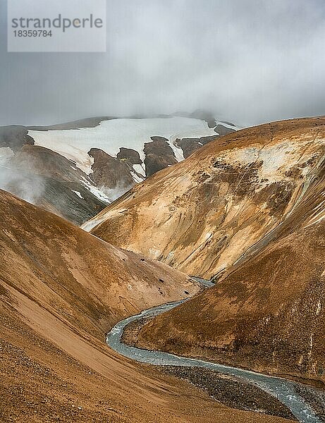 Dampfender Bach zwischen bunten Rhyolith Bergen mit Schneefeldern  Geothermalgebiet Hveradalir  Kerlingarfjöll  isländisches Hochland  Island  Europa