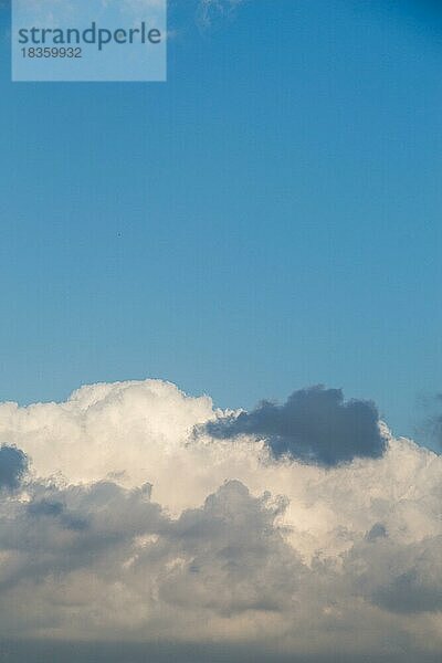 Weiße Farbwolken bedecken den blauen Himmel am Tag