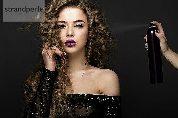 Schönes brünettes Modell mit klassischem Make-up und einer Flasche Haarpflegemittel. beauty face. Porträtaufnahme im Studio