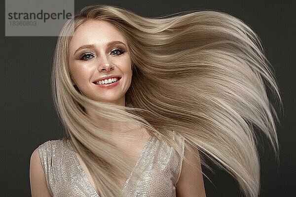 Schönes blondes Mädchen in Bewegung mit einem perfekt glatten Haar  und klassisches Make-up. Schönes Gesicht. Bild im Studio aufgenommen