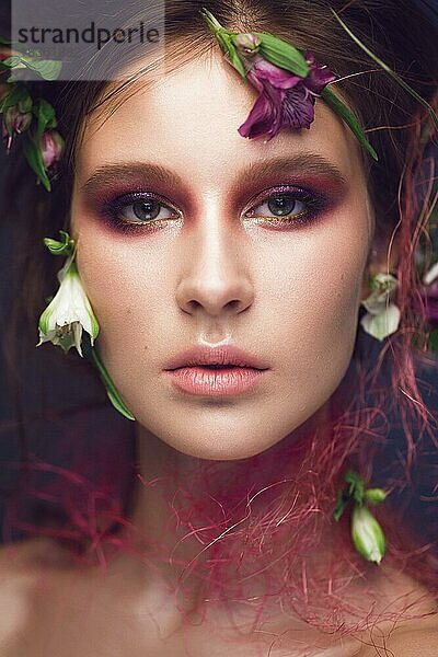 Schönes Mädchen mit Kunst Make-up und Blumen. Schönheit Gesicht. Fotos im Studio geschossen