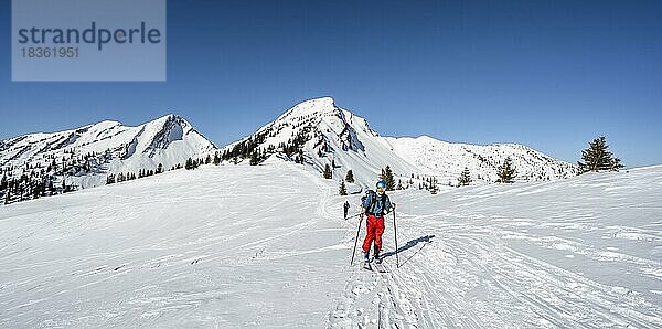 Skitourengeher beim Aufstieg zum Hochgern  hinten verschneite Gipfel Sonntagshorn und Hirscheck  Chiemgauer Alpen  Bayern  Deutschland  Europa