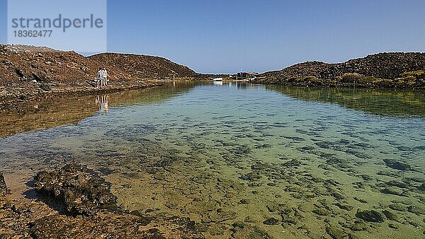 Flache Lagune  grünes Meer  zwei Wanderer  Norden  Insel Los Lobos  Naturschutzgebiet  blauer wolkenloser Himmel  Fuerteventura  Kanarische Inseln  Spanien  Europa