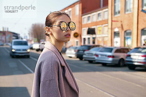 Junges Mädchen beim Überqueren der Straße. Spiegel Sonnenbrille mit Straße reflektiert in ihm