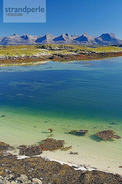 Glasklares Wasser in einer seichten Bucht  Sicht auf das Bergmassiv Sieben Schwestern  Insel Heröy FV 17  Kystriksveien  Nordland  Norwegen  Europa