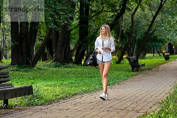 Mädchen auf dem Gehweg im Park  das sich ausruht und den warmen Abend genießt