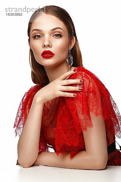 Schönes Mädchen in rotem Kleid mit klassischem Make-up und roter Maniküre. Schönes Gesicht. Foto im Studio aufgenommen