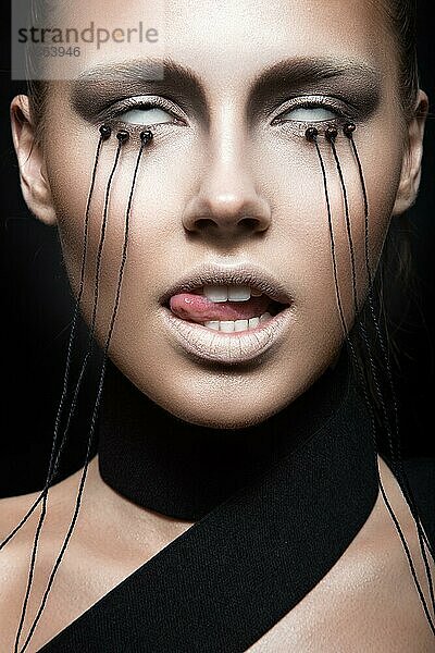 Schönes Mädchen mit kreativen Make-up im Gothic-Stil und die Fäden der Augen. Kunst Schönheit Gesicht. Bild im Studio auf einem schwarzen Hintergrund genommen