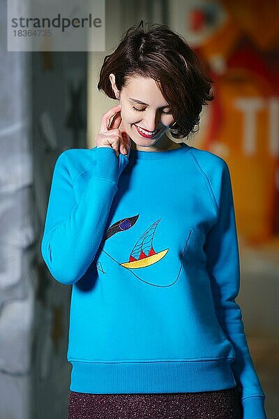 Tricky Girl in blauem Fleece-Sweatshirt schaut nach unten