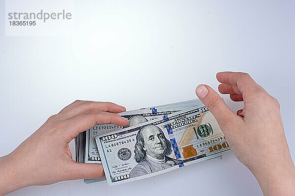 Menschliche Hand hält amerikanischen Dollar-Schein als Geld vor weißem Hintergrund