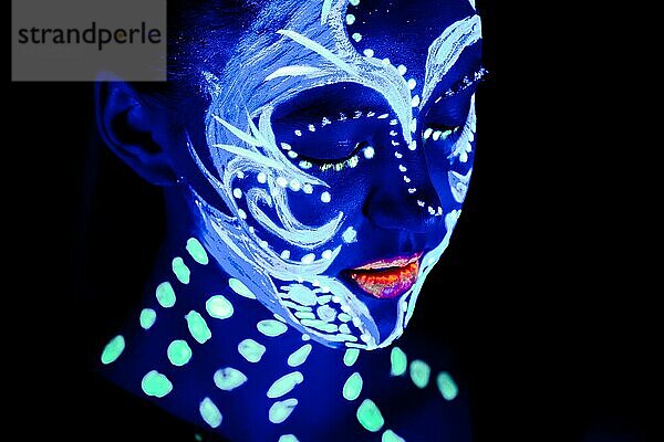 Porträt eines schönen Mädchens mit ultravioletter Farbe im Gesicht. Mädchen mit Neon-Make-up in Farbe Licht