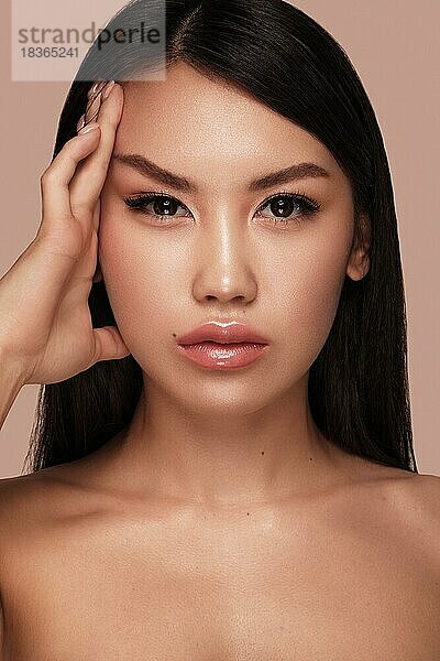 Schöne zarte Frau des orientalischen Typs mit nacktem Make-up und perfekter Haut. Schönes Gesicht. Spa-Salon