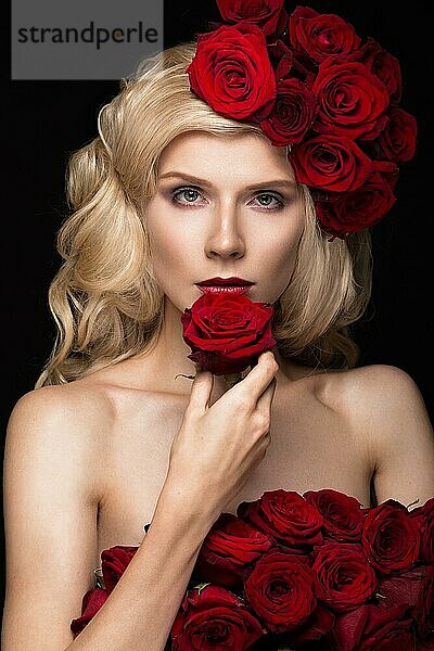 Schönes blondes Mädchen in einem Kleid und Hut mit Rosen  klassischem Make-up  Locken und roten Lippen. Schönes Gesicht. Fotos im Studio aufgenommen