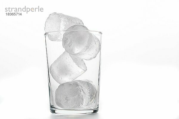 Glasbecher mit Eiswürfeln im Vordergrund weißer Hintergrund und Kopie Raum