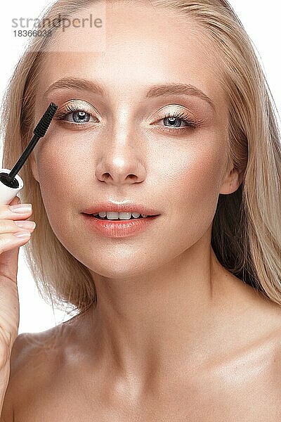 Schönes junges Mädchen mit einem leichten natürlichen Make-up  Mascara und nackter Maniküre. Schönes Gesicht. Bild im Studio auf einem weißen Hintergrund genommen