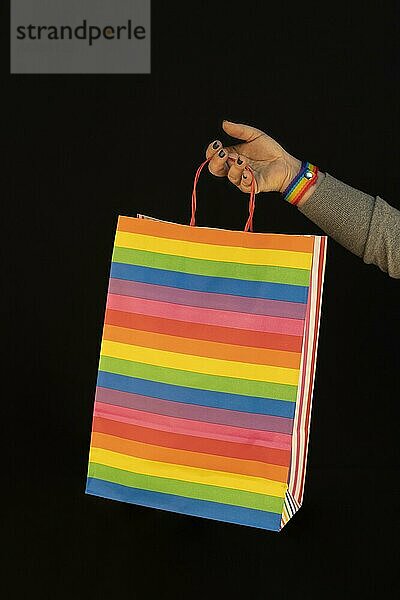 Shopping lgbt Tasche in den Händen der Frau. Freude am Konsum. Käufe  schwarzer Freitag  Rabatte  Verkauf Konzept. Schwarzer Hintergrund