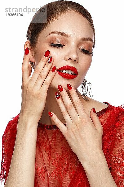 Schönes Mädchen in rotem Kleid mit klassischem Make-up und roter Maniküre. Schönes Gesicht. Foto im Studio aufgenommen