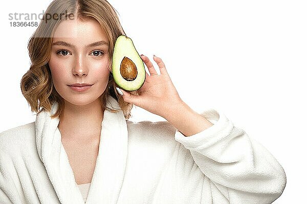 Schönes zartes junges Mädchen in einem weißen Mantel mit sauberer frischer Haut posiert vor der Kamera. Schönes Gesicht. Hautpflege. Foto im Studio auf einem weißen isolieren Hintergrund genommen