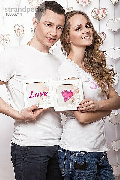 Junge  schöne Frau und Mann in der Liebe am Valentinstag  Laughing Happy Lovers  zeigt verschiedene Posen. Bild im Studio mit Dekorationen genommen
