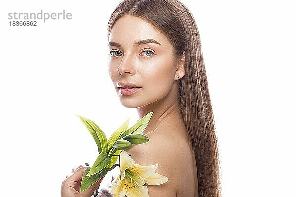 Schönes junges Mädchen mit einem leichten natürlichen Make-up und perfekter Haut mit Blumen in der Hand. Schönes Gesicht. Bild im Studio auf einem weißen Hintergrund aufgenommen