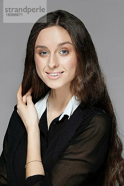 Porträt eines hübschen lächelnden Mädchens mit natürlichem Make-up in schwarzer Bluse mit weißem Kragen