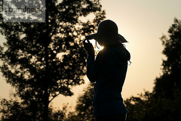 Junge Frau mit Hut entspannt im Sommer Sonnenuntergang Himmel im Freien. Menschen Freiheit Stil