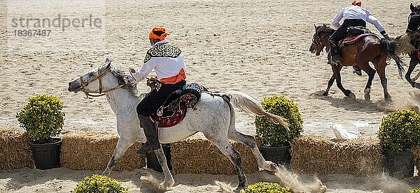 Reiter in ihrer ethnischen Kleidung auf dem Pferderücken
