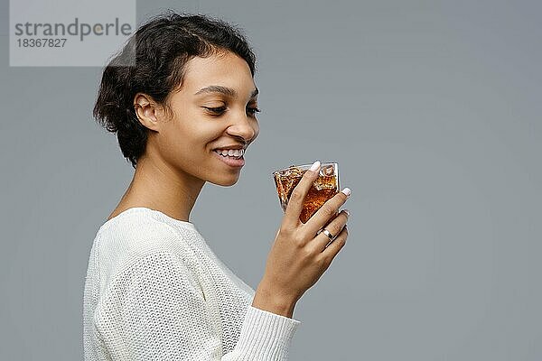 Closeup-Porträt der jungen afroamerikanischen Frau mit einem Glas Cola mit Eis in der Hand
