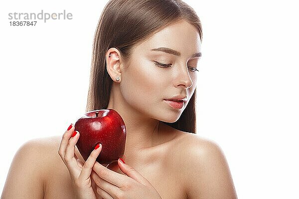 Schönes junges Mädchen mit einem leichten natürlichen Make-up und perfekter Haut mit Apfel in der Hand. Schönes Gesicht. Bild im Studio auf einem weißen Hintergrund genommen