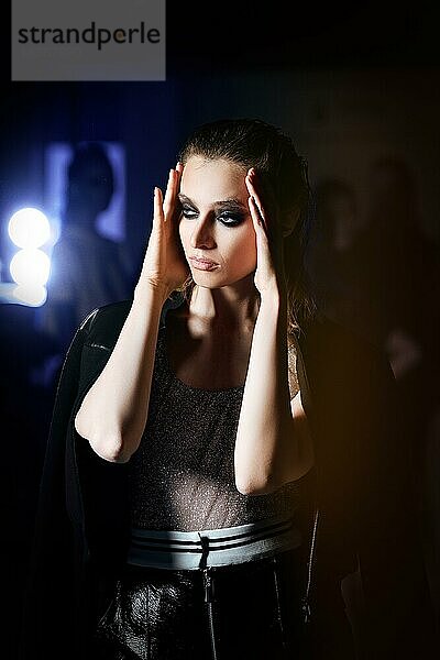 Low-Key-Porträt eines Mädchens in einem dunklen Raum. Spotlight Beleuchtung Mode-Modell an Backstage