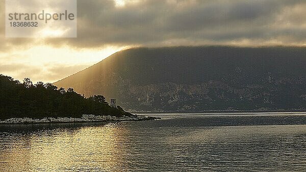 Morgenlicht  Morgenstimmung  Sonnenstrahlen  Sonnenaufgang hinter Ithaka  Runder Venezianischer Leuchtturm  Hafenort  Fiskardo  Insel Kefalonia  Ionische Inseln  Griechenland  Europa