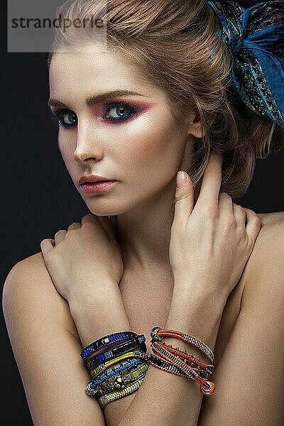 Schöne Mode Mädchen in einem Schal und Armbänder Boho-Stil. Schönheit Gesicht  helle trendy Make-up. Bild im Studio aufgenommen